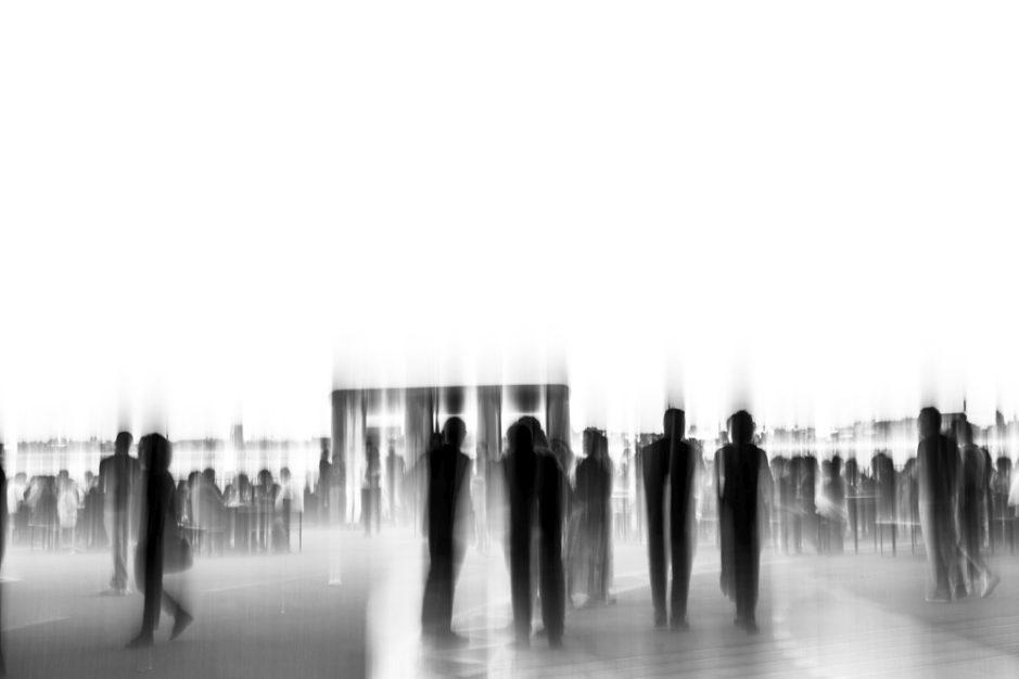 Verschwommene Silhouetten von Menschen in einer urbanen Umgebung.